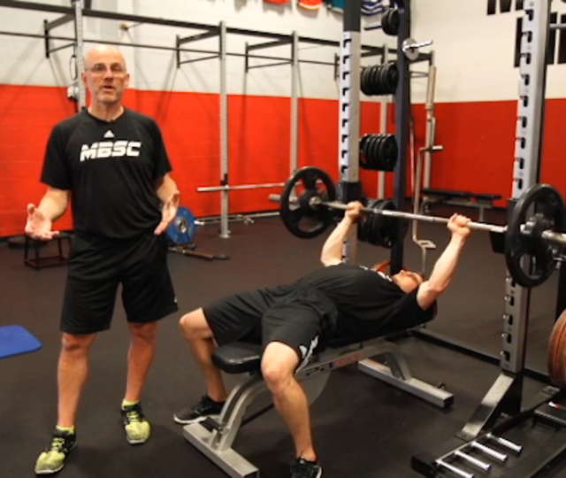 Mike Boyle spotting an athlete during a bench press at MBSC