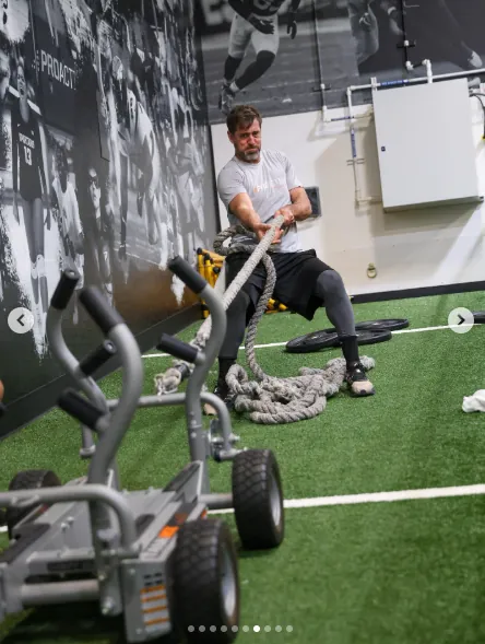 Aaron Rodgers pulling a weighted sled with battle ropes at Proactive